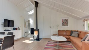 A modern living room with a fireplace, a sofa, a TV, and a dining area. - Gorgeous home in Sydals with WiFi (Sydals)
