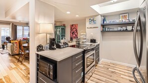 Una cocina moderna con una isla central, horno empotrado y refrigerador.