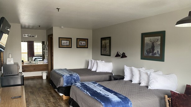 A hotel room with two beds, a desk, a sink, and a mirror. - Standard Double Queen Room (Branson)