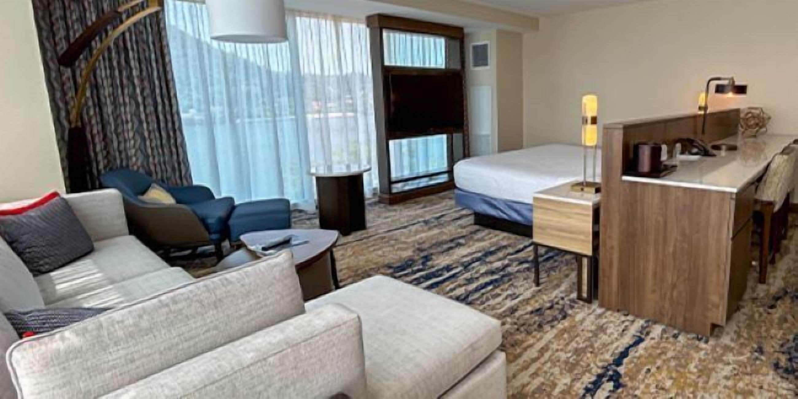 Una habitación de hotel con cama, sofá, escritorio y silla.