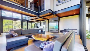 A spacious living area with a large sofa set, a wooden coffee table, and a flat-screen TV. - Odyssey Villa - incredible mountain views, 3 bedrooms, w pool! (Peréz Zeledon)