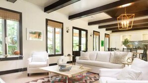 A modern living room with white furniture, a patterned rug, and large windows with blinds. - 2 Villas @ Windswept Residences (Frigate Bay)