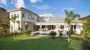 A large, two-story house with a covered patio and a swimming pool. - 2 Villas @ Windswept Residences (Frigate Bay)