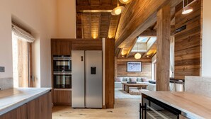Une cuisine moderne avec des éléments en bois, des appareils en acier inoxydable et un îlot central.