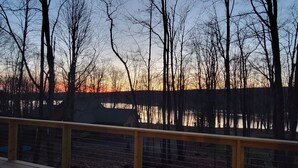 A wooden deck with a metal railing overlooking a body of water and trees. - Clover House at Alpine Lake with pool access. (Terra Alta)