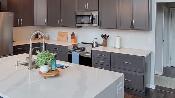 A modern kitchen with a large island, dark cabinets, and a wooden ceiling. - Clover House at Alpine Lake with pool access. (Terra Alta)