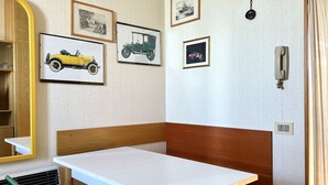 A room with a wooden headboard, a white table, and framed pictures on the wall. - SE054 - Senigallia, sea-front studio at the Residence''Pyramids'' (Senigallia)