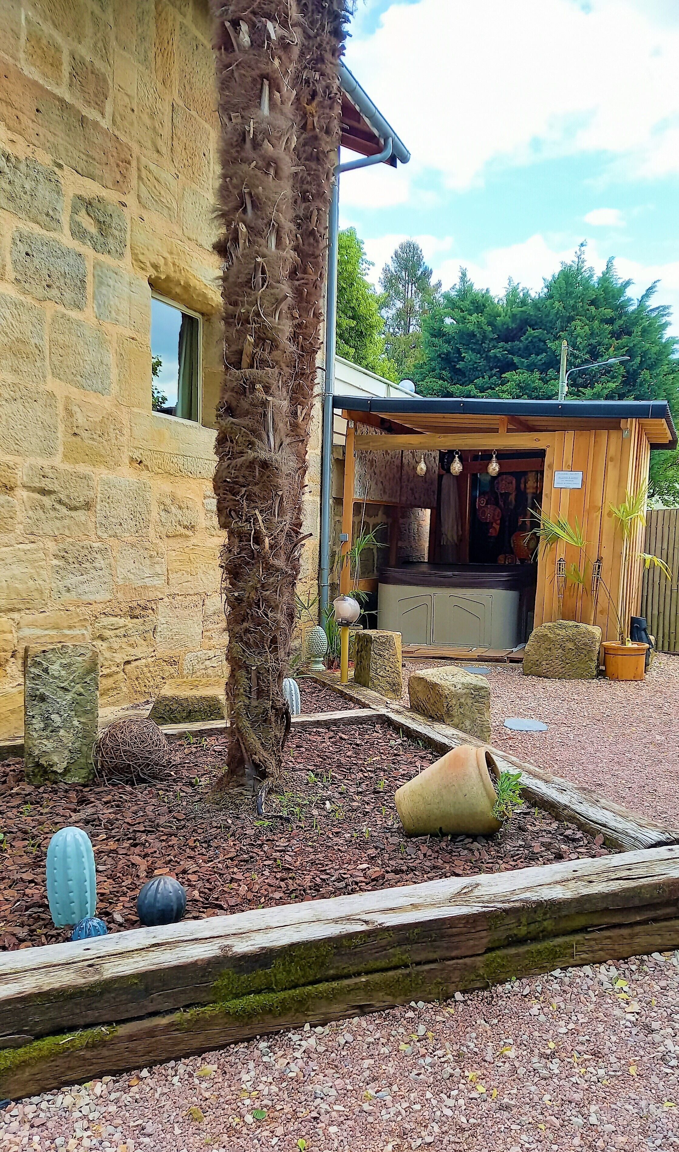 A rustic stone building with a wooden structure adjacent to it.