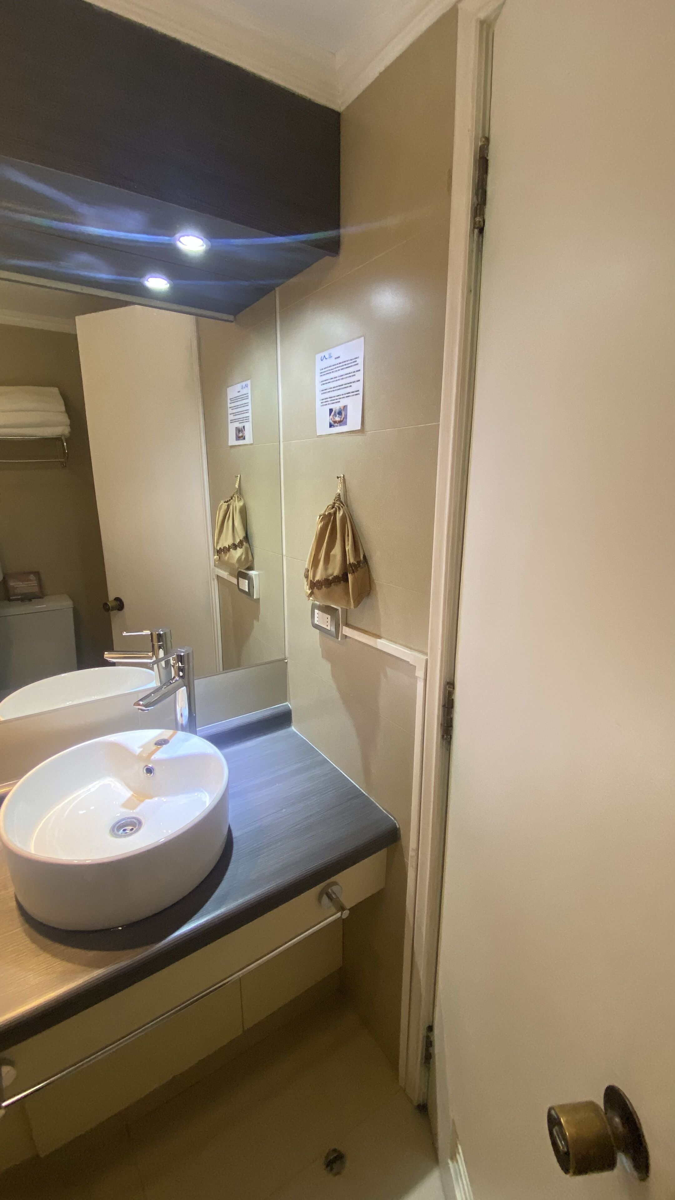 Une salle de bain avec un lavabo rond, un miroir et un porte-serviettes.