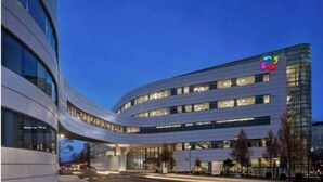 Un bâtiment moderne doté d’une façade incurvée, de plusieurs étages et de grandes fenêtres.