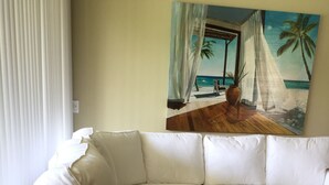 Un sofà modular blanc en una habitació amb un quadre de temàtica marítima a la paret.