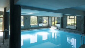 A large indoor swimming pool with clear windows, a tiled floor, and a metal handrail. - Hotel y Cabañas Huallilemu Sur- Caja Los Andes (El Quisco)