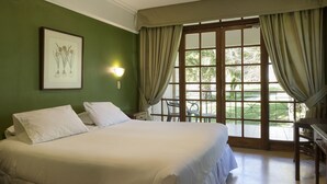 A hotel room with a large bed, a desk, and a window with curtains. - Hotel y Cabañas Huallilemu Sur- Caja Los Andes (El Quisco)