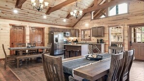 A rustic wooden interior with a dining area, kitchen, and bar.