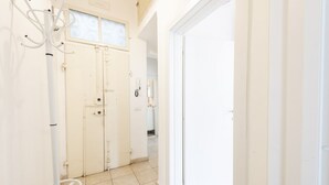A hallway with a coat rack, double doors, and a tiled floor. - Mosse 82 apartment in Florence by Mmega (Firenze)