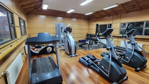 A gym with various exercise machines, large windows, and wooden flooring. - Hotel y Cabañas Las Mellizas - Caja Los Andes (Los Angeles)