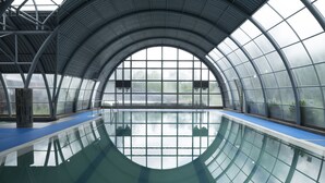 An indoor swimming pool with a glass ceiling and blue poolside area. - Hotel y Cabañas Las Mellizas - Caja Los Andes (Los Angeles)