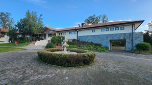 A building with a stone facade, a central fountain, and a staircase leading to the entrance. - Hotel y Cabañas Las Mellizas - Caja Los Andes (Los Angeles)