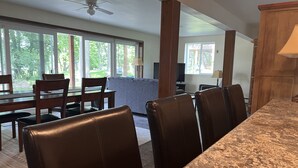 A modern kitchen with a granite countertop and dark leather chairs.