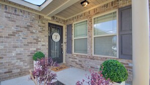 A brick house with a dark front door, a welcome mat, and two potted plants. - Cozy Corner <7 miles from Toyota Field and Redstone Arsenal - family-friendly! (Madison)