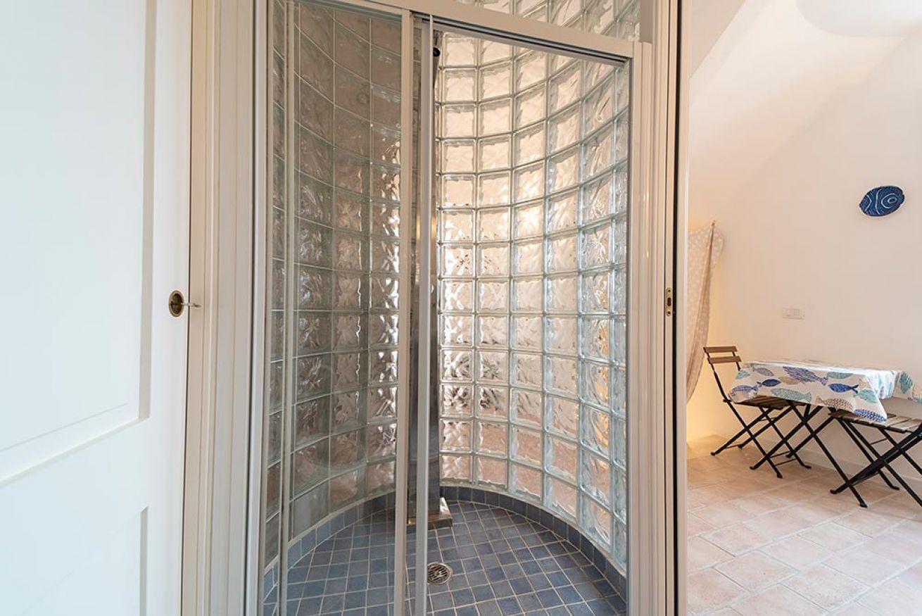 A room with a glass partition, a tiled floor, and a table with chairs.
