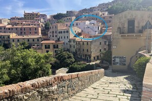 A historic town with stone buildings, a cobblestone street, and a stone wall. - Villa Il Guardingo in Rio Elba (Rio Nell'Elba)