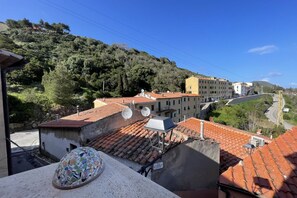 A view of a hillside town with terracotta-roofed buildings, a mosaic-tiled structure, and satellite dishes. - Villa Il Guardingo in Rio Elba (Rio Nell'Elba)