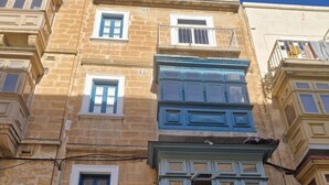 Un edificio de varios pisos con arquitectura tradicional, que cuenta con balcones y ventanas amplias.
