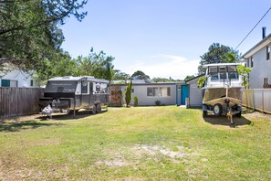 A residential area with a mobile home, a trailer, and a house.