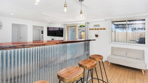 Een moderne keuken met een centraal eiland, barstoelen en hanglampen.