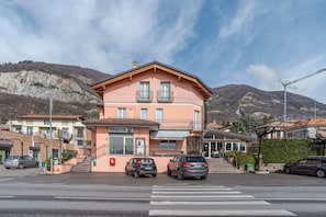 A building with a balcony, a sign reading 'TABACCHI,' and a crosswalk in front.