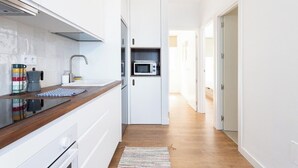 A modern kitchen with white cabinetry, a wooden countertop, a microwave, and a coffee maker. - Home2Book Bright Sea Views Apartment & Pool (Bajamar)