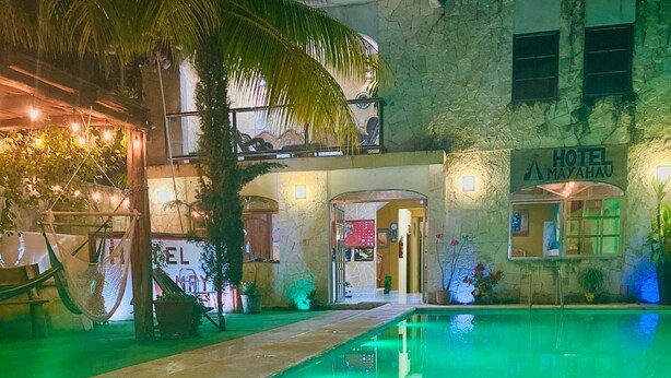 Un hôtel doté d'un espace piscine, d'une enseigne indiquant le nom de l'hôtel et d'une entrée.