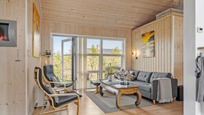 A cozy room with wooden walls, a grey sofa, a wooden coffee table, and a chaise lounge. - 3 bedroom gorgeous home in Storvorde (Storvorde)