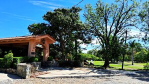 A building with a covered entrance, a paved area, and a golf cart.