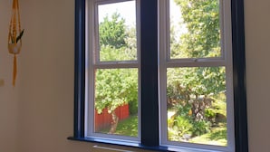 A room with a large window overlooking a garden.