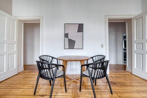 Cozy space with a round table and four chairs, featuring a modern abstract painting and symmetrical layout.