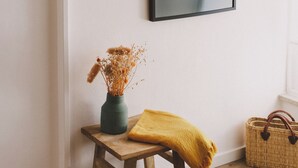 A wooden bench with a vase and a yellow throw blanket against a wall. - Chão do Ribeirinho, Castelo Branco (Fundao)