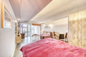 Een moderne slaapkamer met een groot bed, een bureau en een kledingkast.
