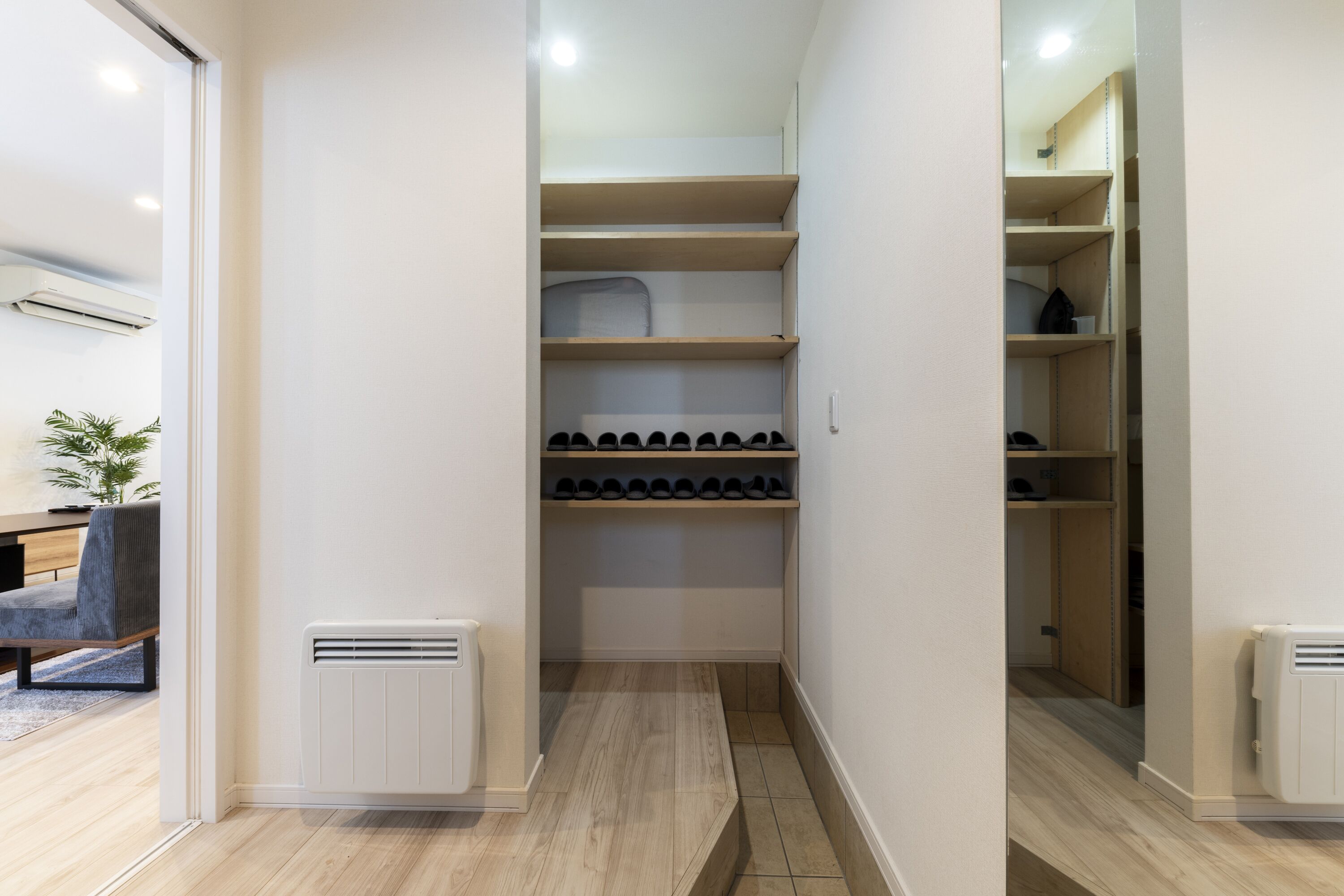 Um closet amplo com várias prateleiras e um sapateiro.