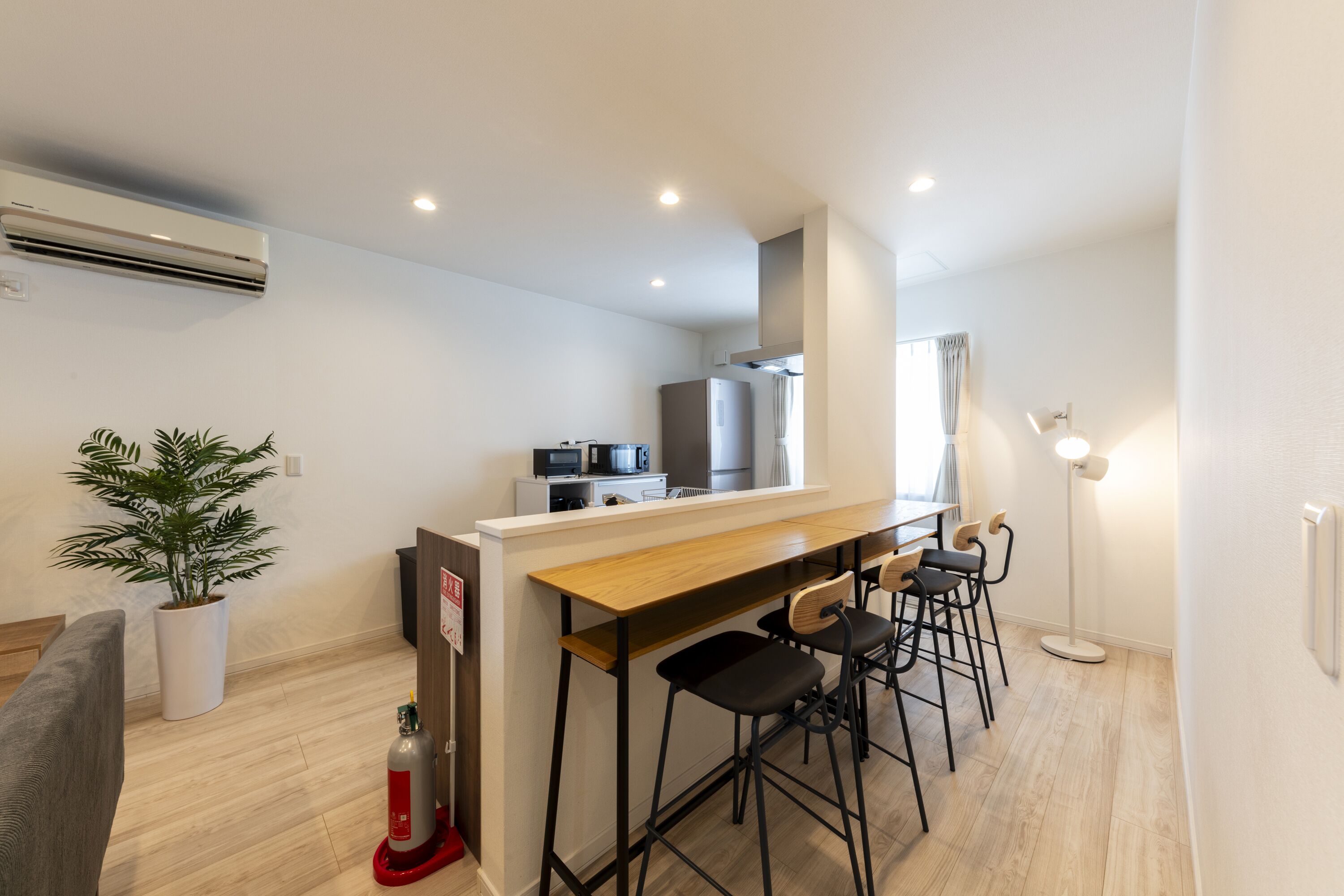 Une cuisine moderne avec un plan de travail en bois, des tabourets de bar et un four encastré.