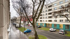 Ein mehrgeschossiges Wohngebäude mit Parkplatz davor.