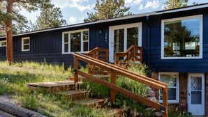 Eine moderne Holzhütte mit einer Holztreppe, die zu einer Glastür führt.