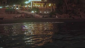 A beachfront property with a multi-level building, a staircase leading to the entrance, and palm trees in the background. - Costa Madrangca (San Jose de Buenavista)