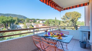 A balcony with a table set for breakfast, overlooking a scenic landscape. - Sémaphore by Interhome (Cavalaire)