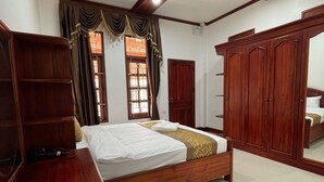 Un dormitorio con cama de madera, un armario y un ventilador de techo.