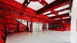 Un interior espacioso con suelo de mármol pulido, paneles de madera y una zona de recepción con mostrador y asientos.