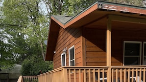 A wooden cabin with a deck and a covered porch. - Cozy cabin in delightful Wisconsin Dells- Cabin A (Wisconsin Dells)
