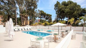 A poolside area with lounge chairs, umbrellas, and a pool. - MARTA BEACH 1 – Beachfront apartment in Benissa (Benissa)