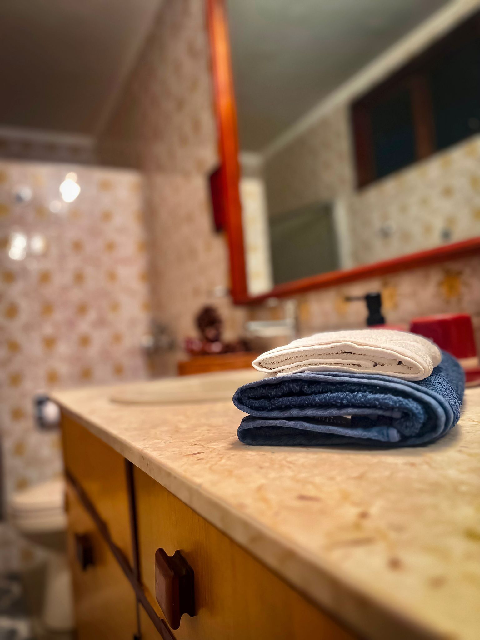 Una encimera de cocina con una pila de toallas dobladas y un armario de madera.